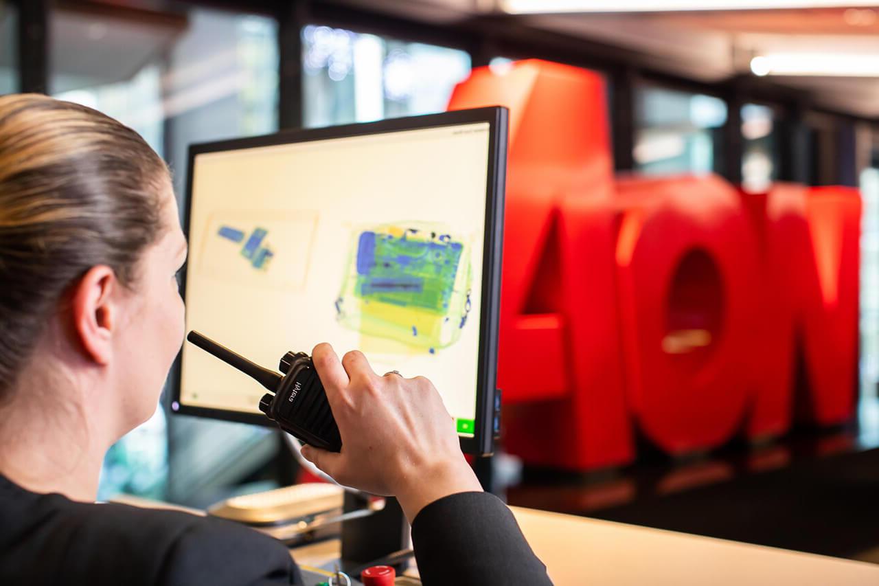 Female security guard using a walkie-talkie at Aon offices